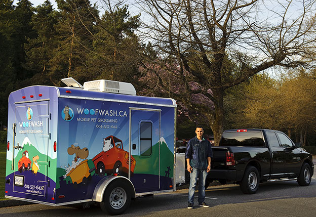 The Woof Wash mobile grooming trailer, wrapped in playful artwork, parked and ready for an appointment